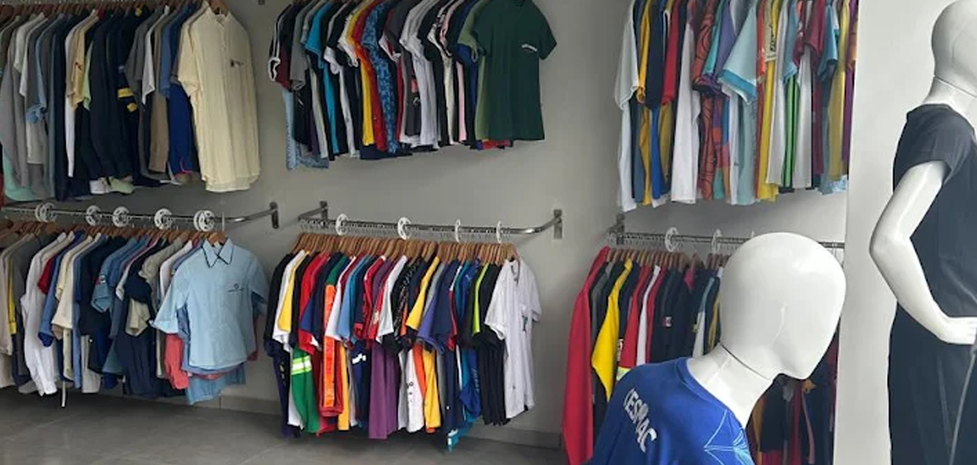 Roupas produzidas pela loja penduradas em cabides